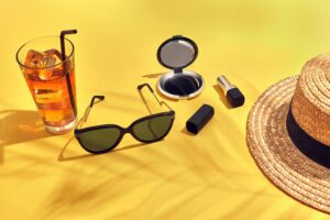 straw-beach-woman-s-hat-beverage-with-ice-glass-sunglasses-yellow-background_157927-2089